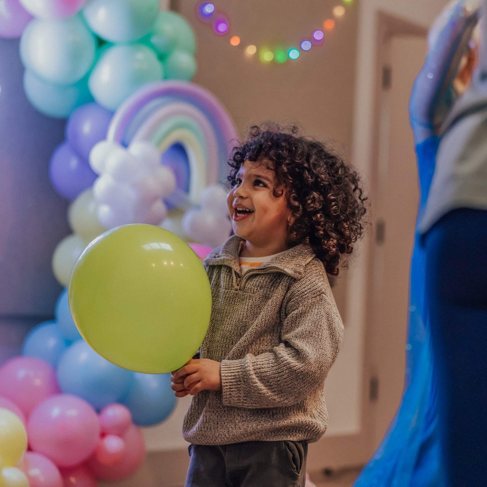 A child holding a yellow balloon at a party