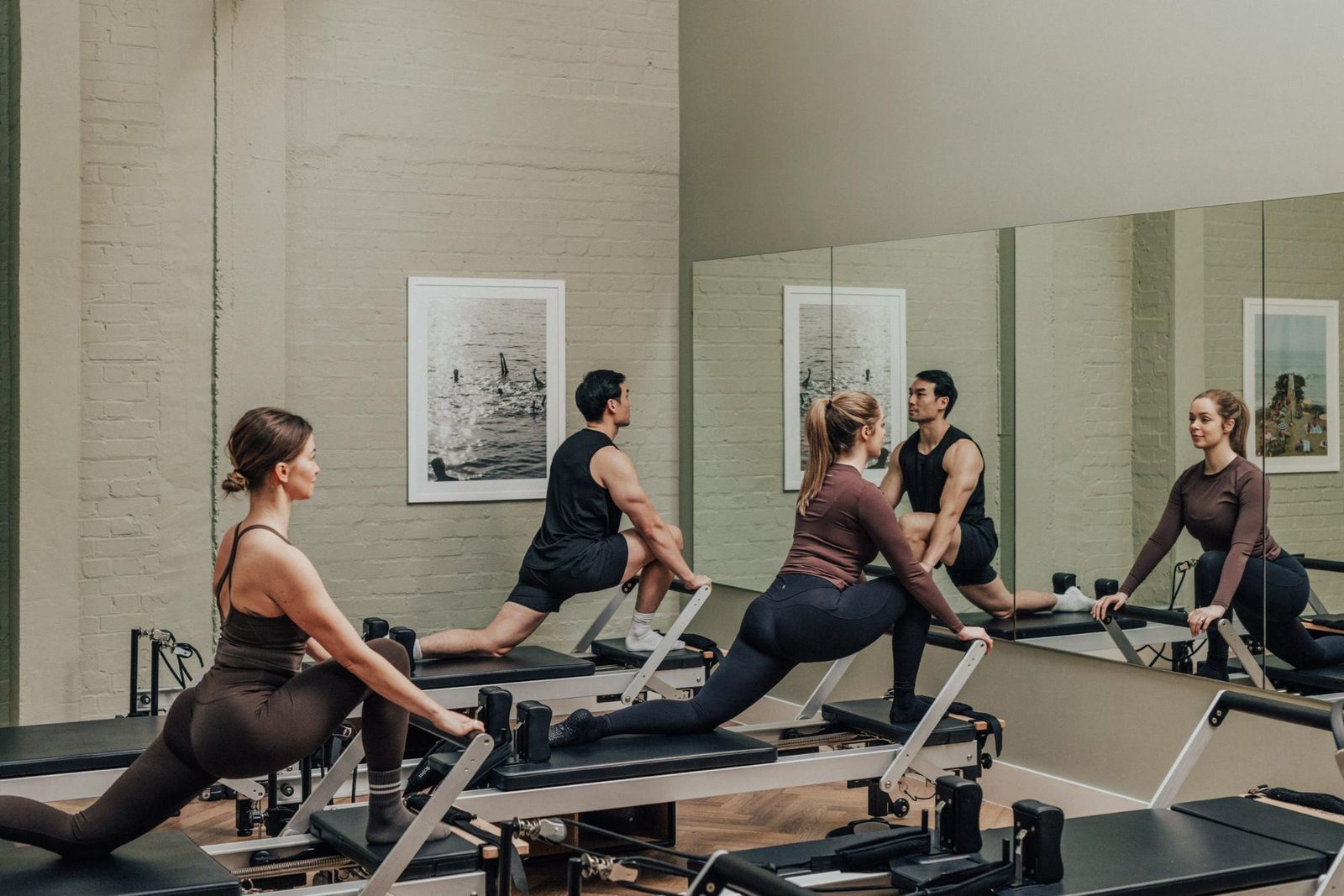 Two people on Reformer Pilates machines in the studio at Jesse’s House